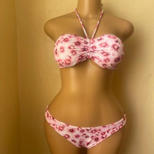 bikini is predominantly white with an all-over pink and reddish-pink floral print.